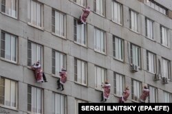 RUSSIA - Russian firemen and rescuers dressed in costumes of Father Frost (or Ded Moroz, or Santa Claus) descend along a wall from the roof of Morozovskaya Children's hospital.