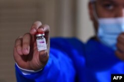 A nurse holds a vial of the AstraZeneca COVID-19 vial at "Santo Domingo" nursing home, Asuncion, Paraguay, on April 10, 2021. (Photo by NORBERTO DUARTE / AFP)