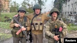 In this video still, founder of the Russian mercenary Wagner Group, Yevgeny Prigozhin (center), poses with mercenaries "Biber" and "Dolik" in Bakhmut on May 25, 2023. (Concord press service/Reuters)