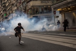 Riot police deploy tear gas as they clear protesters from a road during a rally against a new national security law in Hong Kong on July 1, 2020.