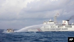 In this handout photo provided by the Philippine Coast Guard, a Chinese Coast Guard ship uses water cannons on Philippine navy-operated supply boat M/L Kalayaan as it approaches Second Thomas Shoal in the disputed South China Sea on Dec. 10, 2023. (Philippine Coast Guard via AP)