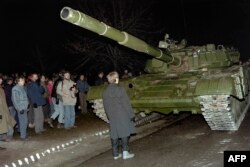 Lithuania -- Lithuanian demonstrator stands in front of a Soviet Red Army tank