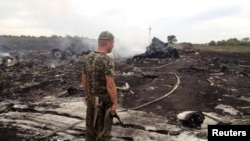 Ukraine -- An armed pro-Russian separatist stands near the settlement of Grabovo, at a site of a Malaysia Airlines Boeing 777, downed by a missile in the Donetsk region, July 17, 2014.