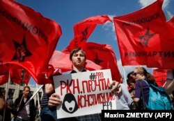 RUSSIA -- A man holds a poster reading "RKN (Roskomnadzor - the Federal Service for Supervision of Communications, Information Technology and Mass Media) read the constitution!" during an opposition rally in central Moscow on May 13, 2018.