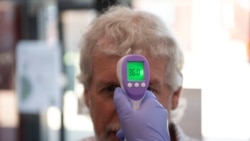 A patient has his temperature taken with a non-contact infrared thermometer on arrival at Freshney Green Primary Care Centre in Grimsby, Britain June 9, 2020.