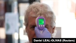 A patient has his temperature taken with a non-contact infrared thermometer on arrival at Freshney Green Primary Care Centre in Grimsby, Britain June 9, 2020.