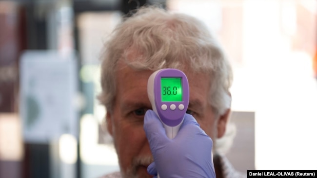 A patient has his temperature taken with a non-contact infrared thermometer on arrival at Freshney Green Primary Care Centre in Grimsby, Britain June 9, 2020.