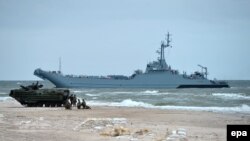 Poland -- The Assault Amphibious Vehicle (AAV7) (front) and Polish minelayer-landing ship (back) during the BALTOPS 17 exercises on the beach in Ustka, June 14, 2017