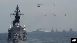 Japan escort ship "Kurama" leads other vessels and aircraft ahead of triennial Maritime Self-Defense Force fleet review off Sagami Bay, October 15, 2015.