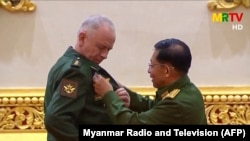 Russia's Deputy Defense Minister Alekaandr Fomin (L) receives a medal from Myanmar armed forces chief Senior General Min Aung Hlaing in Naypyidaw on March 26, 2021. (Myanmar Radio and Television/via AFP)