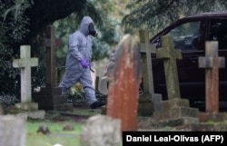 Emergency personnel look for clues at the London Road Cemetery in Salisbury, where the wife and son of poisoned former double agent Sergei Skripal are buried, March 10, 2018.