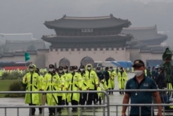 Police officers wearing face masks to help protect against the spread of the coronavirus patrol around the Gyeongbok Palace, one of South Korea's well-known landmarks, in Seoul, South Korea, Saturday, Aug. 15, 2020.