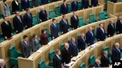 Lawmakers of Federation Council of the Federal Assembly listen to the national anthem after giving Russian President Vladimir Putin permission to use military force outside the country on Feb. 22, 2022. (Federation Council of the Federal Assembly of the Russian Federation via AP)