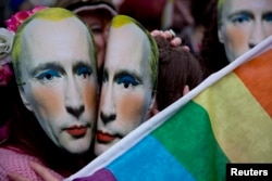 U.K. -- Protesters wearing masks of Russia's President Vladimir Putin pretend to kiss as they take part in a demonstration against the country's 'anti-gay' laws outside the Embassy of the Russian Federation in London, February 14, 2014