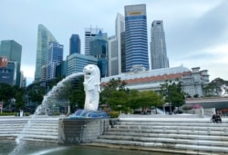 A couple sits near the Merlion statue, a popular tourist landmark, on Monday, May 31, 2021. (Annabelle Liang/AP)