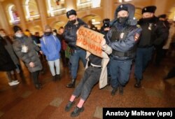 Police detain a protester with a placard reading 'Freedom for Navalny' at a demonstration in support of Russian opposition leader and anti-corruption activist Alexei Navalny in St.Petersburg, Russia, on 18 January 2021.