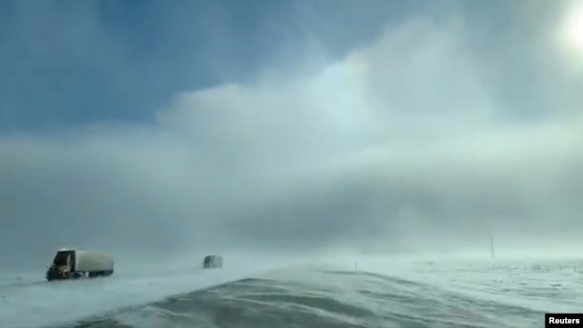 Trucks drive amidst heavy snow near Fargo, North Dakota, U.S., January 29, 2019, in still image taken from a video taken from social media. Carol Bauer/via REUTERS