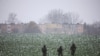 Polish soldiers walk in the field near the site of a purported missile striek in Przewodow, a village in eastern Poland near the border with Ukraine, on November 17, 2022. (Kacper Pempel/Reuters)