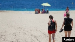 Tourists enjoy the weather at Magaluf beach, following a decision by the British government to ease travel restrictions due to the coronavirus disease (COVID-19) to the island, in Palma de Mallorca, Spain, July 1, 2021. REUTERS/Enrique Calvo