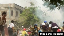Protesters take cover during clashes with security forces in Monywa, Myanmar, on March 21, 2021, in this still image from a video obtained by Reuters. 