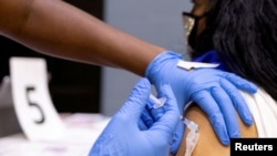 FILE PHOTO: A woman receives a COVID-19 vaccine at a clinic in Philadelphia, Pennsylvania, U.S., May 18, 2021.