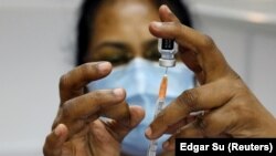 FILE PHOTO: A medical worker prepares a syringe at a coronavirus disease (COVID-19) vaccination center in Singapore, March 8, 2021.