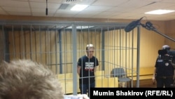 Russian investigative journalist Ivan Golunov stands inside a defendants' cage during a court hearing in Moscow, Russia on June 8, 2019.