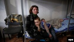 Ukraine -- A woman with children, refugees from the eastern Ukraine conflict zone, are seen in a temporary center for refugees in Slovyansk, Donetsk region, March 12, 2015