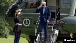 U.S. President Joe Biden salutes a Marine while exiting Marine One on his return from Wilmington, Delaware, on the South Lawn at the White House in Washington, U.S., July 25, 2021. REUTERS/Ken Cedeno