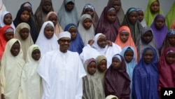 Nigerian President Muhammadu Buhari with school girls released from Boko Haram captivity, Abuja, March 23, 2018. (Azeez Akunleyan/AP)