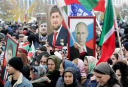 CHECHNYA -- People hold portraits of Russian President Vladimir Putin and Chechen leader Ramzan Kadyrov during a rally marking National Unity Day in Grozny, November 4, 2019