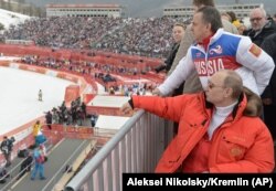 RUSSIA -- Russian President Vladimir Putin, foreground, watches downhill ski competition of the 2014 Winter Paralympics in Roza Khutor mountain district of Sochi, March 8, 2014