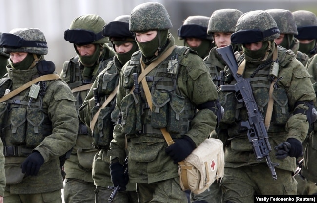 Russian servicemen walk in formation near a Ukrainian military base in the village of Perevalnoye outside Simferopol, Crimea, March 6, 2014.