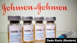 FILE PHOTO: Vials with a sticker reading, "COVID-19 / Coronavirus vaccine / Injection only" and a medical syringe are seen in front of a displayed Johnson & Johnson logo in this illustration taken October 31, 2020. 