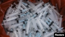 Used syringes lie discarded in a bin after they were used to administer the coronavirus disease (COVID-19) vaccine in Mumbai, India, August 11, 2021. REUTERS/Francis Mascarenhas