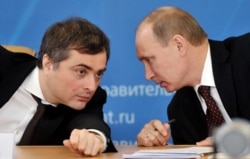 RUSSIA -- Vladimir Putin confers with his aid Vladislav Surkov during a meeting in the city of Kurgan, on February 13, 2012
