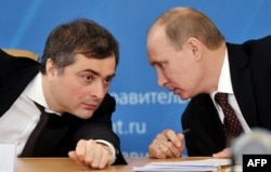 RUSSIA -- Vladimir Putin confers with his aid Vladislav Surkov during a meeting in the city of Kurgan, on February 13, 2012