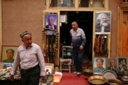 Portraits of China's late Chairman Mao Zedong, Soviet state founder Vladimir Lenin, and German philosopher Karl Marx are displayed outside an antique shop in the old town in Kashgar, Xinjiang Uighur Autonomous Region, China, on March 22, 2017.