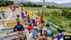 VENEZUELA – Venezuelans returning home amid the new coronavirus pandemic queue to have their documents checked by Colombian migrations officials on the Simon Bolivar International Bridge, on August 21, 2020.