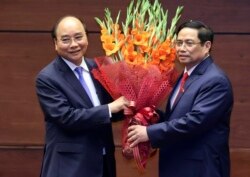Vietnam's newly elected President Nguyen Xuan Phuc, left, and newly elected Prime Minister Pham Minh Chinh pose for a photo in the National Assembly in Hanoi on April 5.