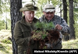 RUSSIA -- Russian President Vladimir Putin and Russian Defense Minister Sergei Shoigu look at vegetation during a short vacation in the remote Tuva region in southern Siberia, August 26, 2018