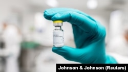 FILE PHOTO: A lab worker holds a vial of Johnson & Johnson's Janssen coronavirus disease (COVID-19) vaccine candidate in an undated photograph. Johnson & Johnson/Handout via REUTERS