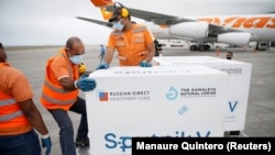 Workers take care of a shipment of Russia's Sputnik V vaccine at the airport in Caracas, Venezuela, on March 29, 2021.