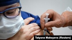 RUSSIA -- A medic of the regional hospital receives Russia's "Sputnik-V" vaccine shot against the coronavirus disease (COVID-19) in Tver, Russia October 12, 2020. 