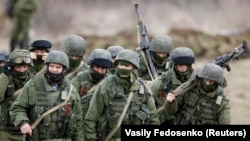 Ukraine - Uniformed men, believed to be Russian servicemen, march outside a Ukrainian military base in the village of Perevalnoye outside Simferopol, March 5, 2014