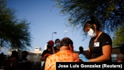 A healthcare worker from the El Paso Fire Department administers the Moderna vaccine against the coronavirus disease (COVID-19) at a vaccination center near the Santa Fe International Bridge, in El Paso, Texas, U.S May 7, 2021.