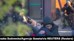 Migrants arrested after crossing Polish-Belarus border are held outside the guard office in Michalowo, Poland, September 27, 2021. (Agnieszka Sadowska/Agencja Gazeta/Reuters) 