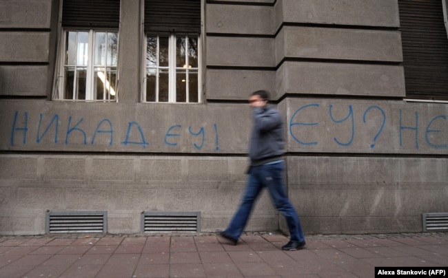 A pedestrian walks past a "Never EU!" graffiti in central Belgrade, December 9, 2011
