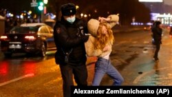 A police officer detains a young woman during a January 23 protest against the jailing of opposition leader Alexey Navalny in Pushkin square in Moscow.