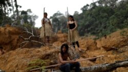 Indigenous people from the Mura tribe show a deforested area in unmarked indigenous lands, inside the Amazon rainforest, on August 20, 2019.